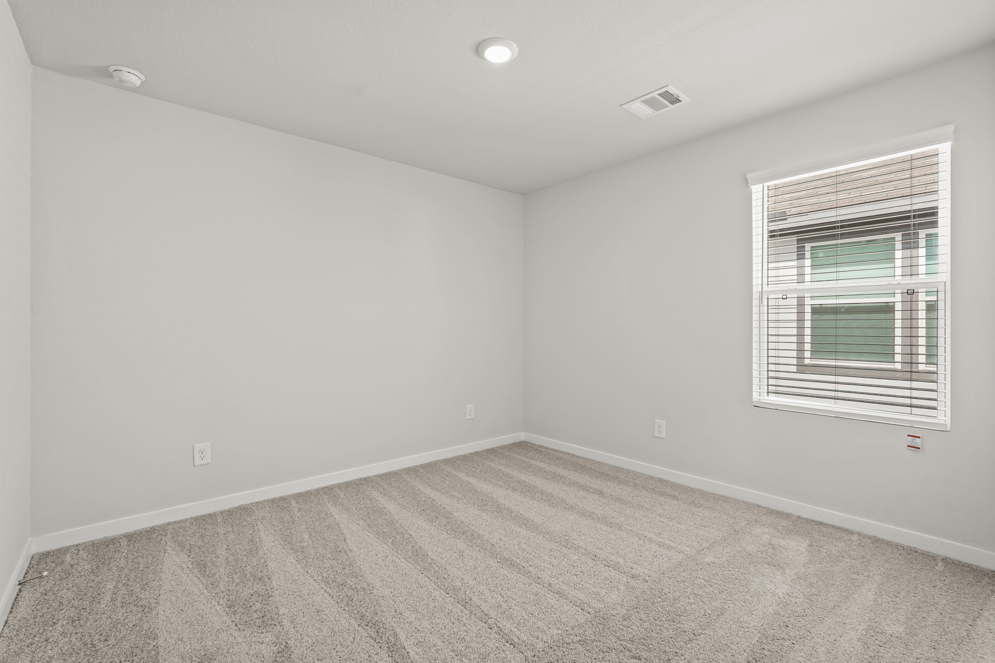 A room with a window and a carpet.