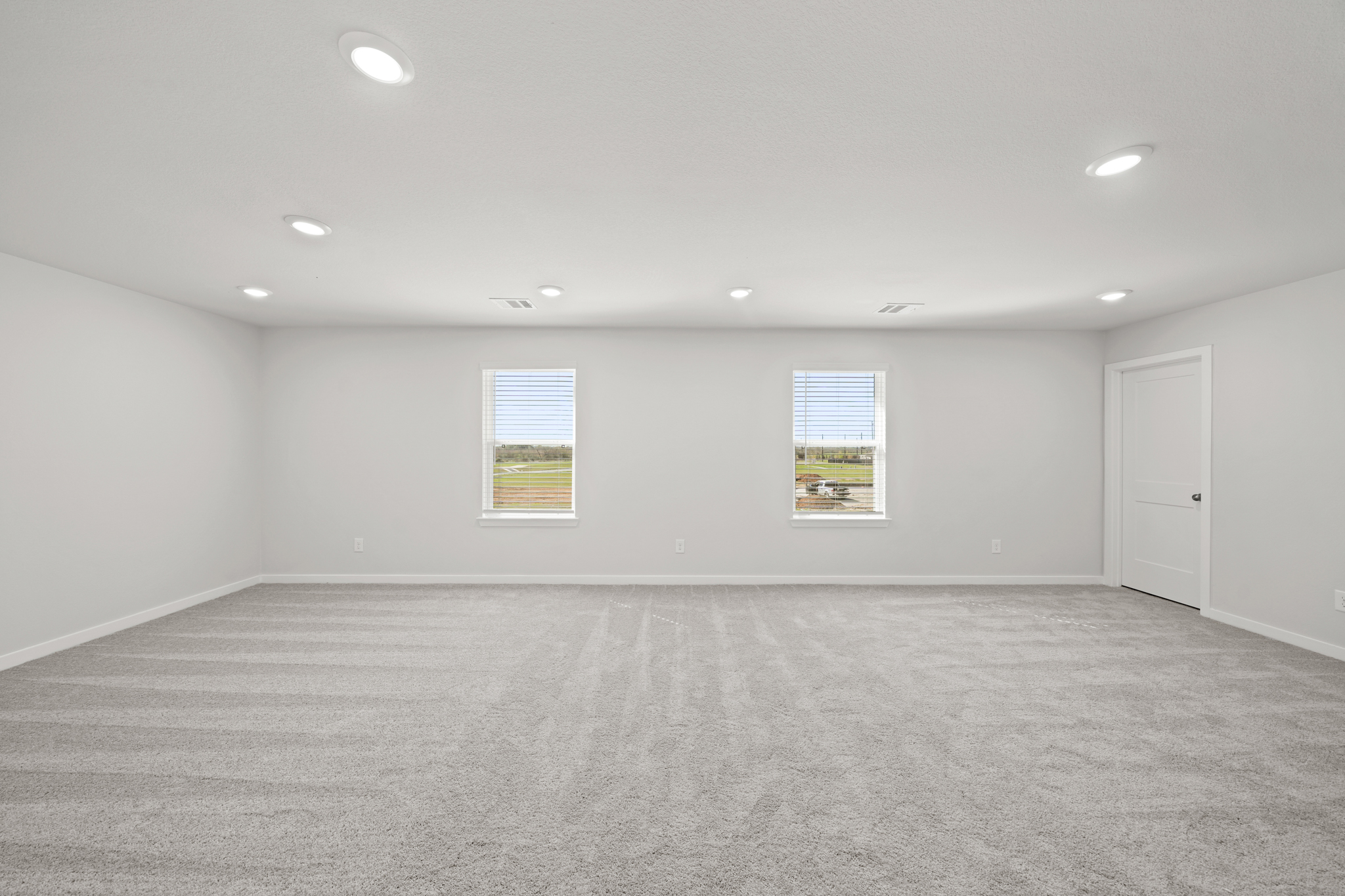 A room with a carpet and a door.