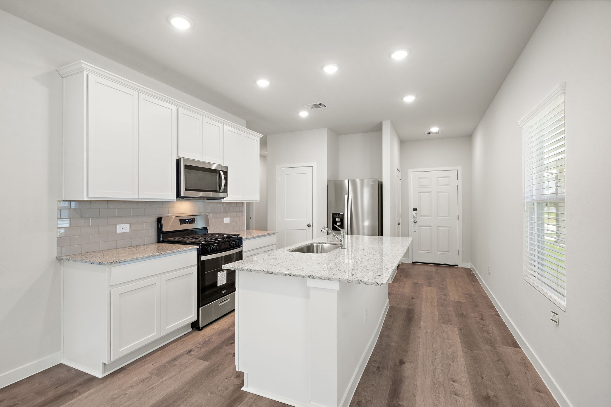 A kitchen with white cabinets.