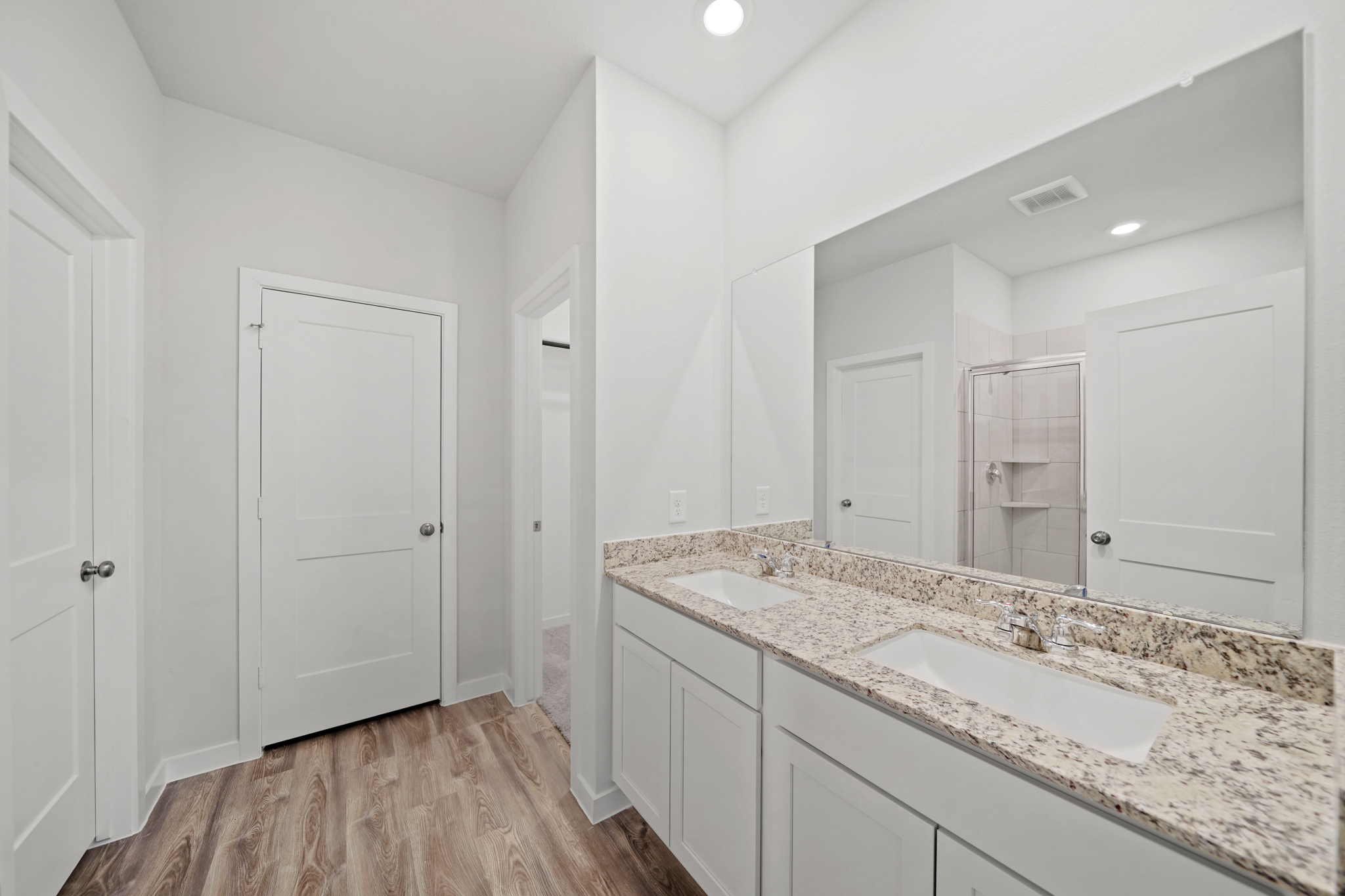 A bathroom with white cabinets.