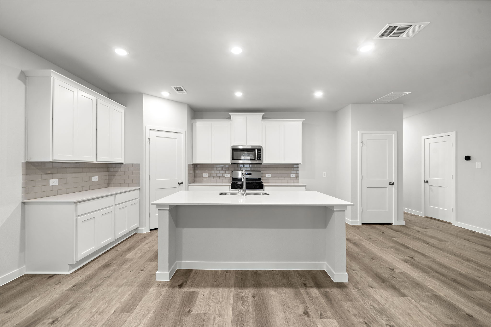 A kitchen with white cabinets.