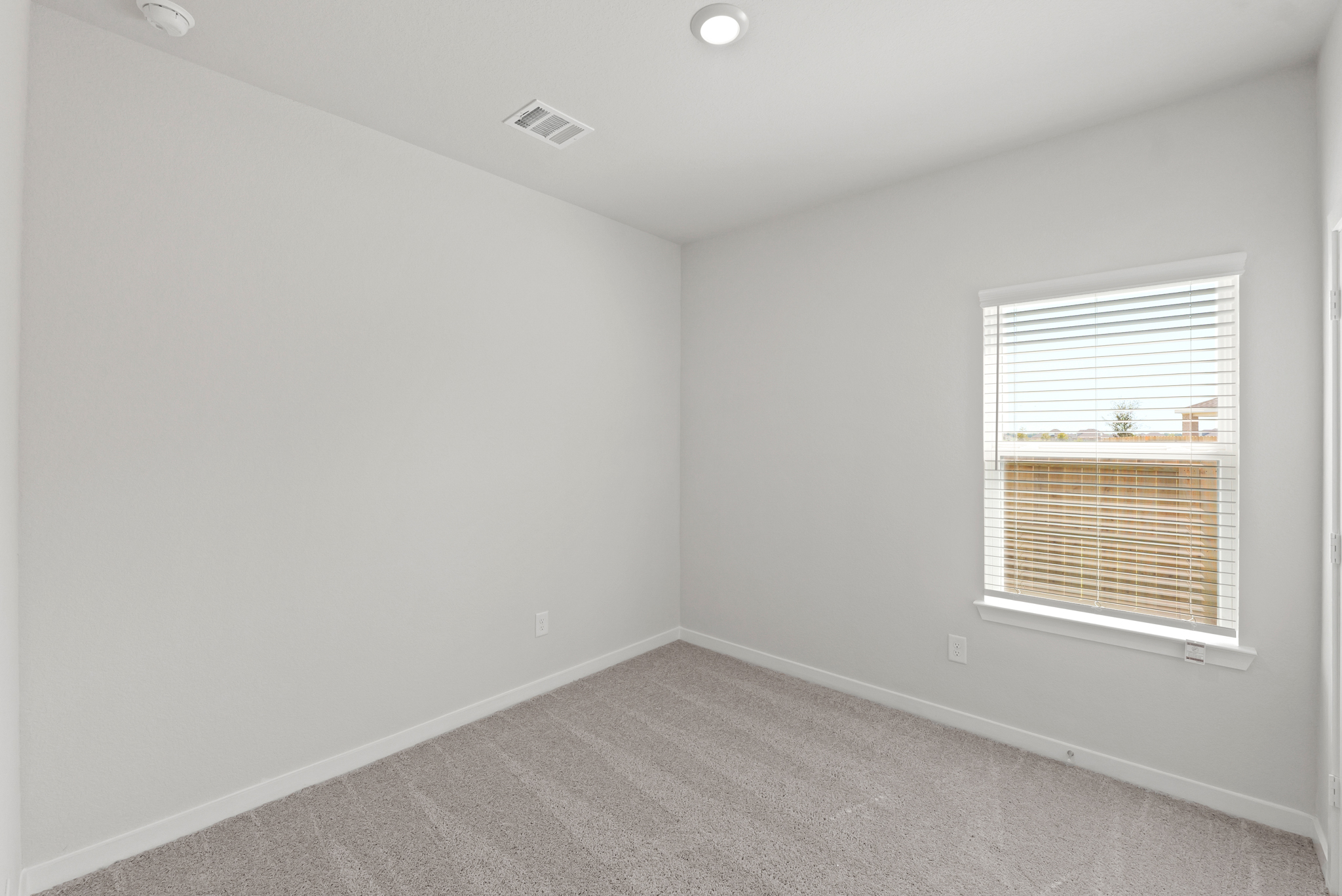 A room with a window and a carpet.