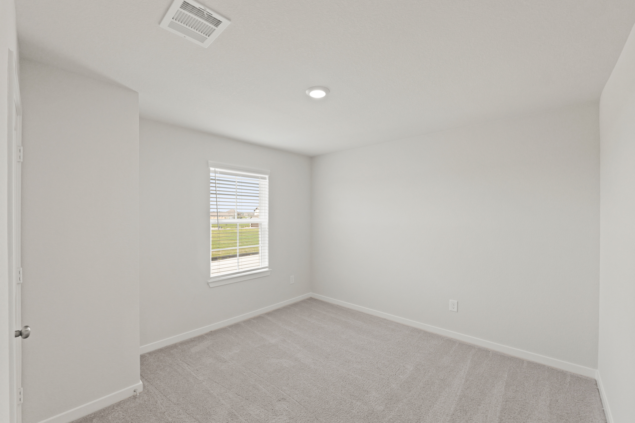 A room with a window and a carpet.