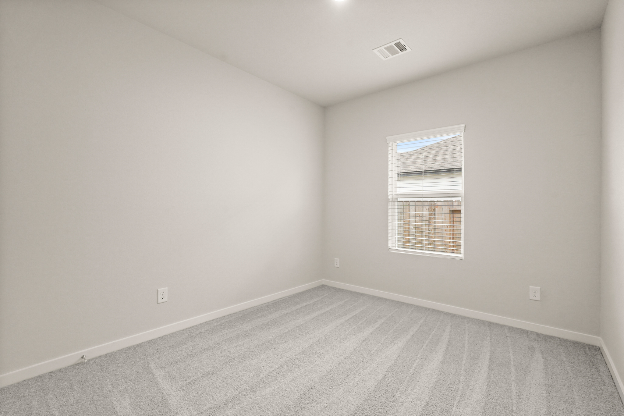 A room with a window and a carpet.