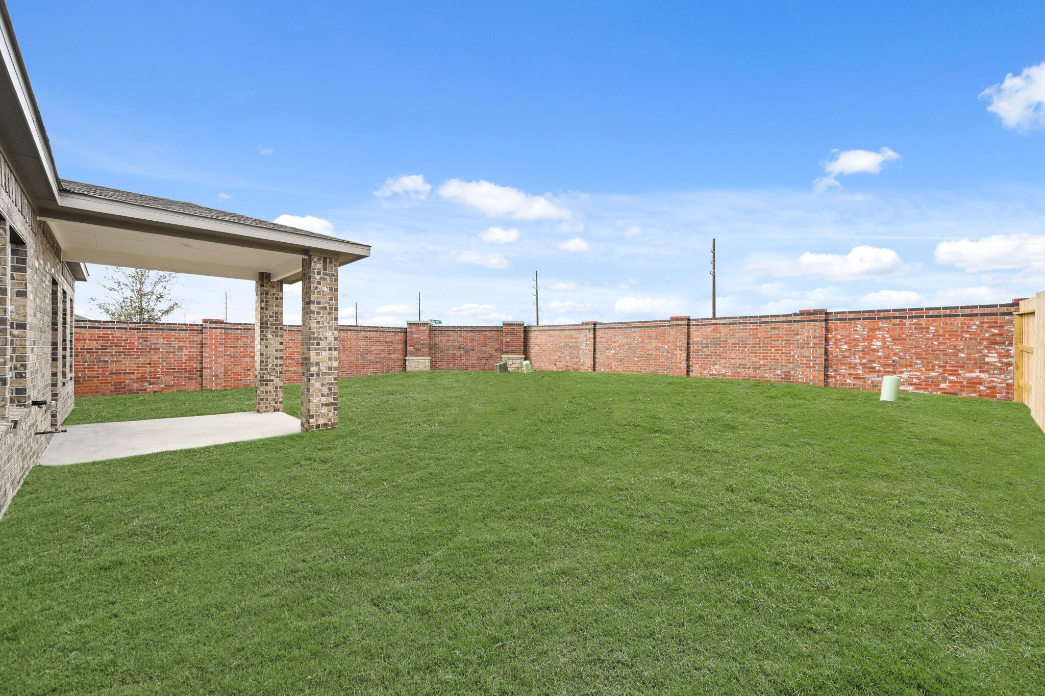 A green lawn in front of a brick building.