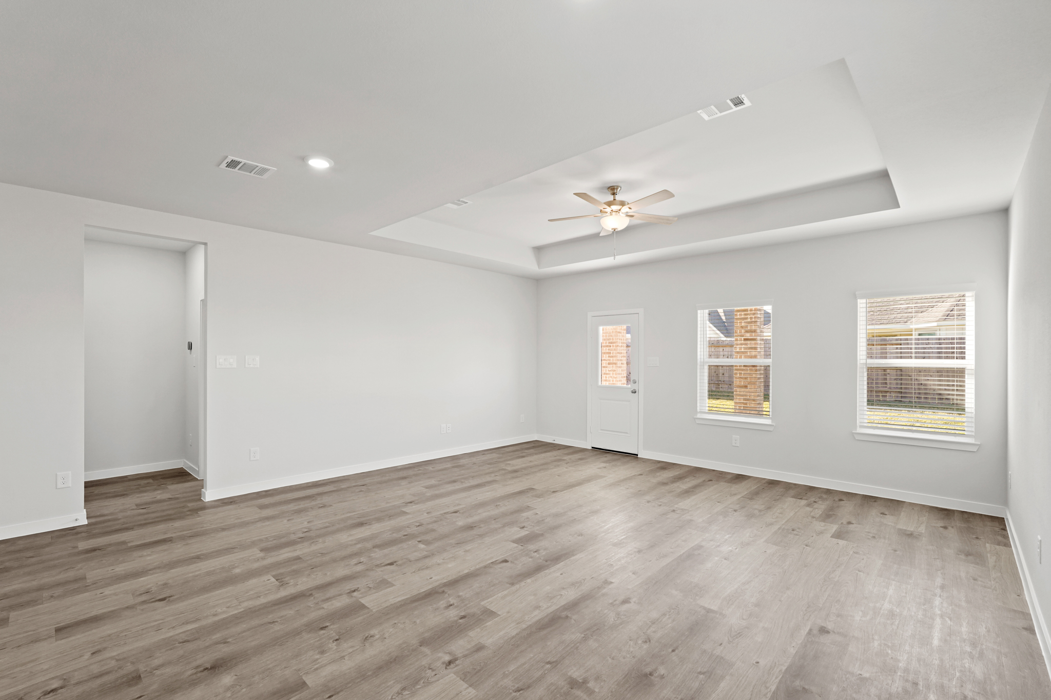 A room with a wood floor and a ceiling fan.