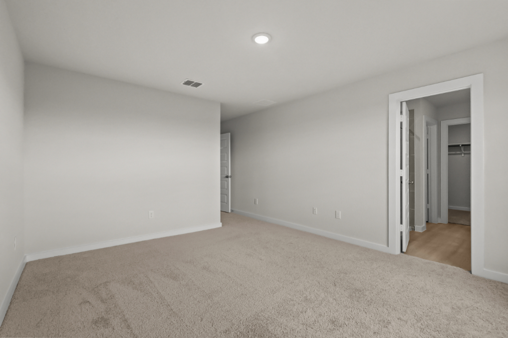 A room with a carpet and a door.