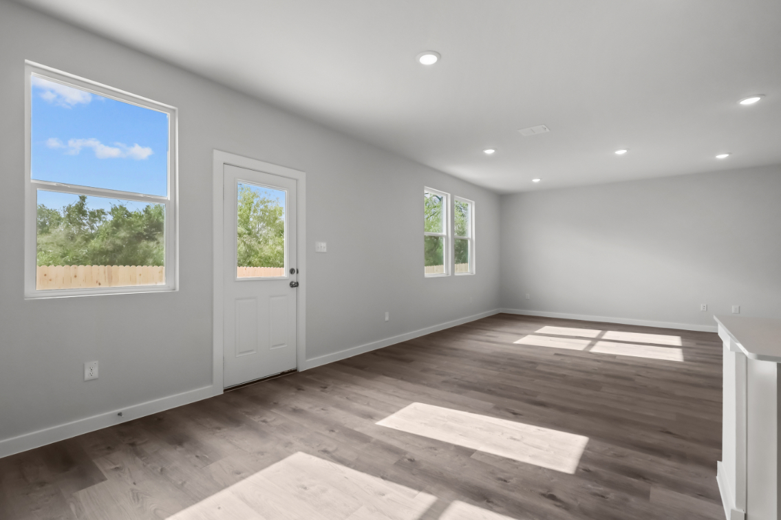 A room with windows and wood floor.