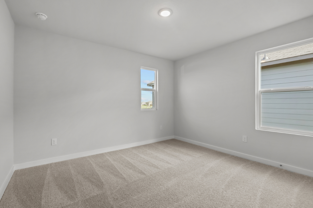 A room with a window and a carpet.