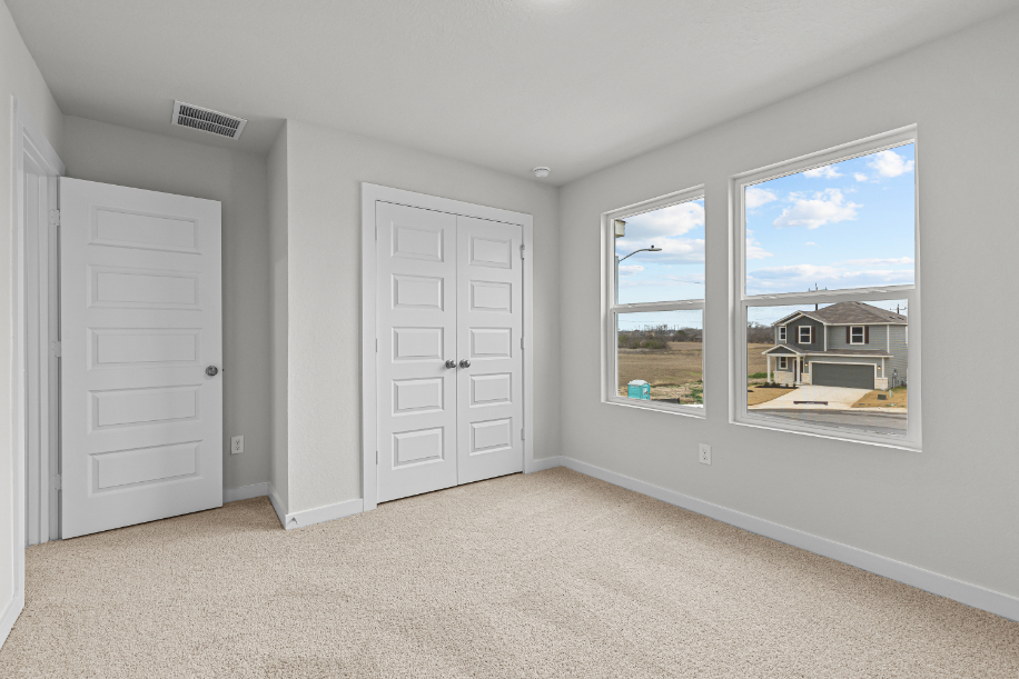 A room with white doors and a window with a view of the ocean.