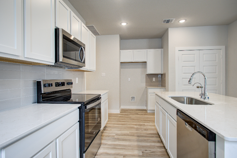 A kitchen with white cabinets.