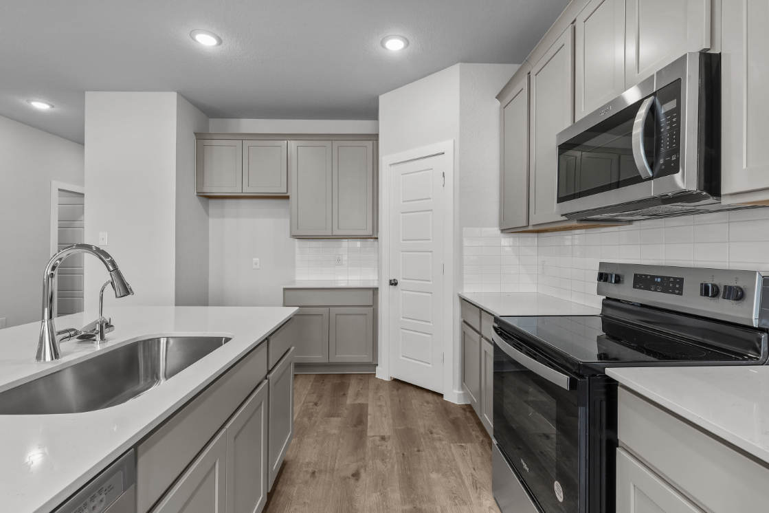 A kitchen with white cabinets.
