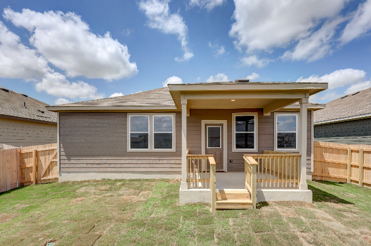 A house with a fence and a yard with a wood fence.