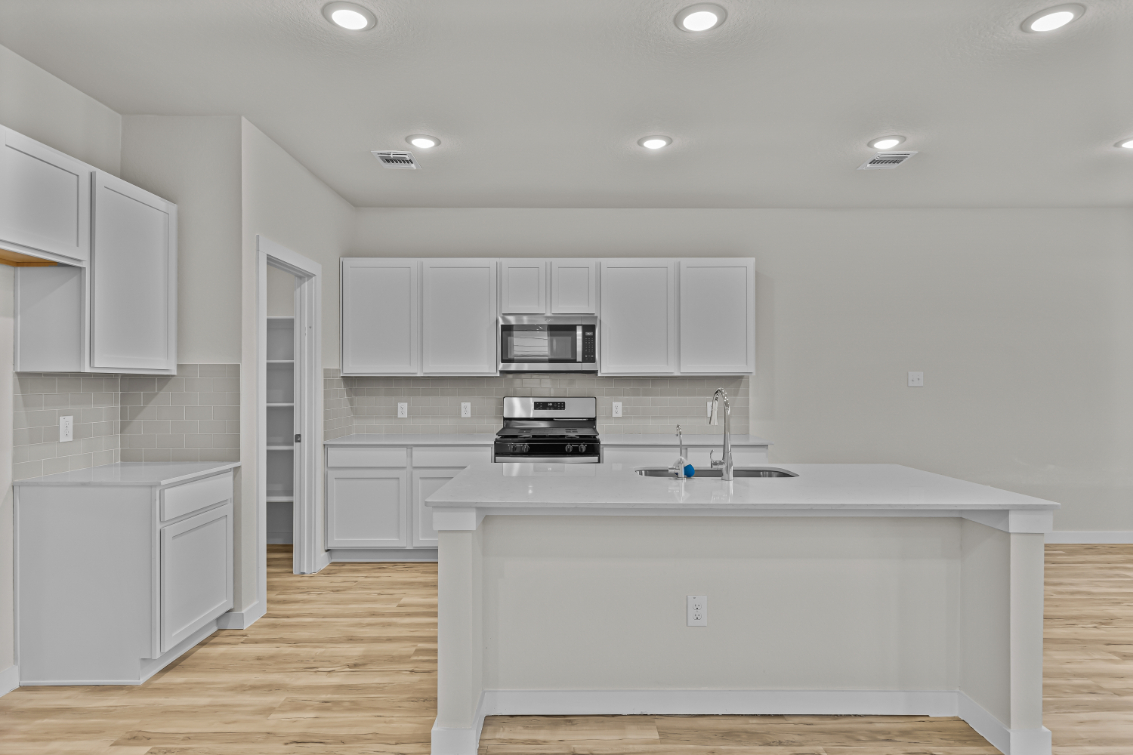 A kitchen with white cabinets.