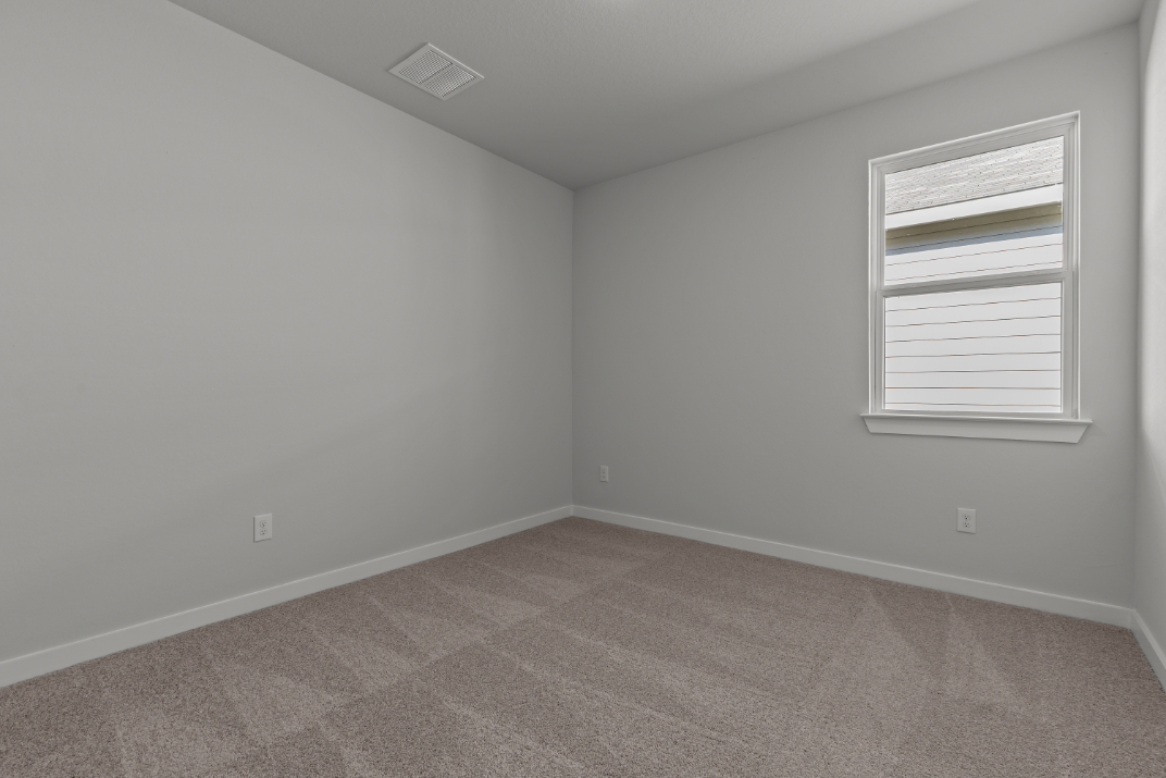 A room with a window and a carpet.