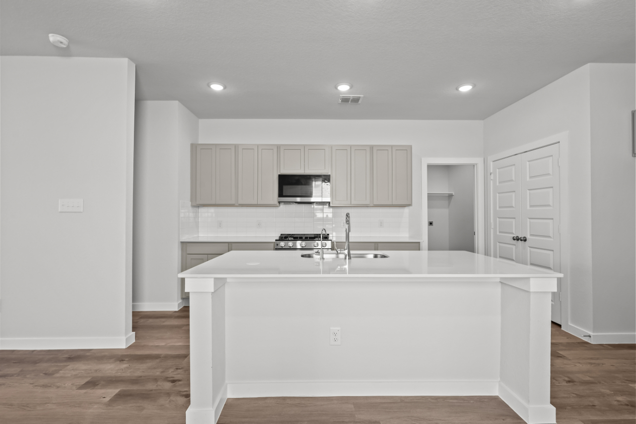 A kitchen with white cabinets.
