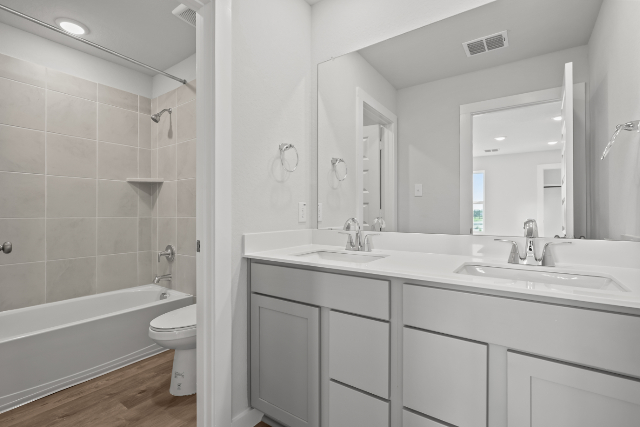 A bathroom with a tub sink and toilet.
