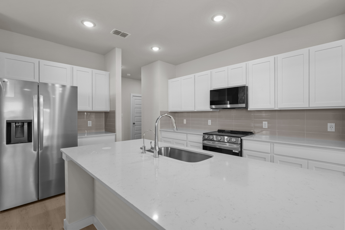 A kitchen with white cabinets.