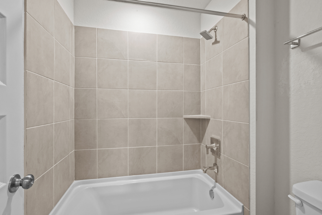 A bathroom with a bathtub and toilet.