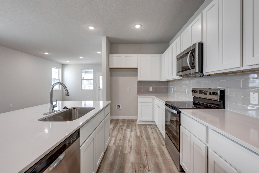 A kitchen with white cabinets.