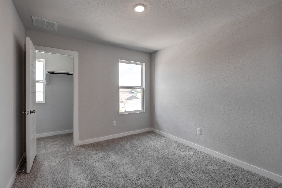 A room with a window and a carpet.