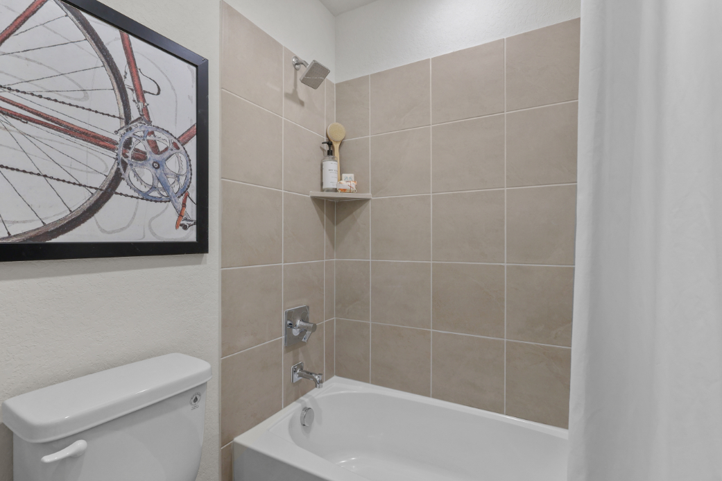 A bathroom with a tub and a mirror.