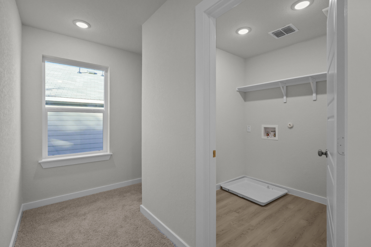 A room with a window and a shelf.