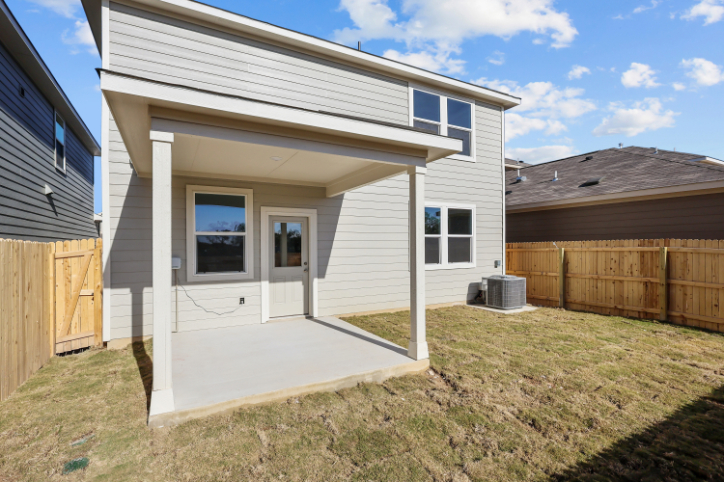 A house with a fence and a yard with a wood fence.