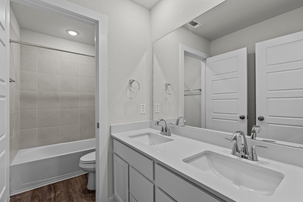 A bathroom with a tub sink and toilet.
