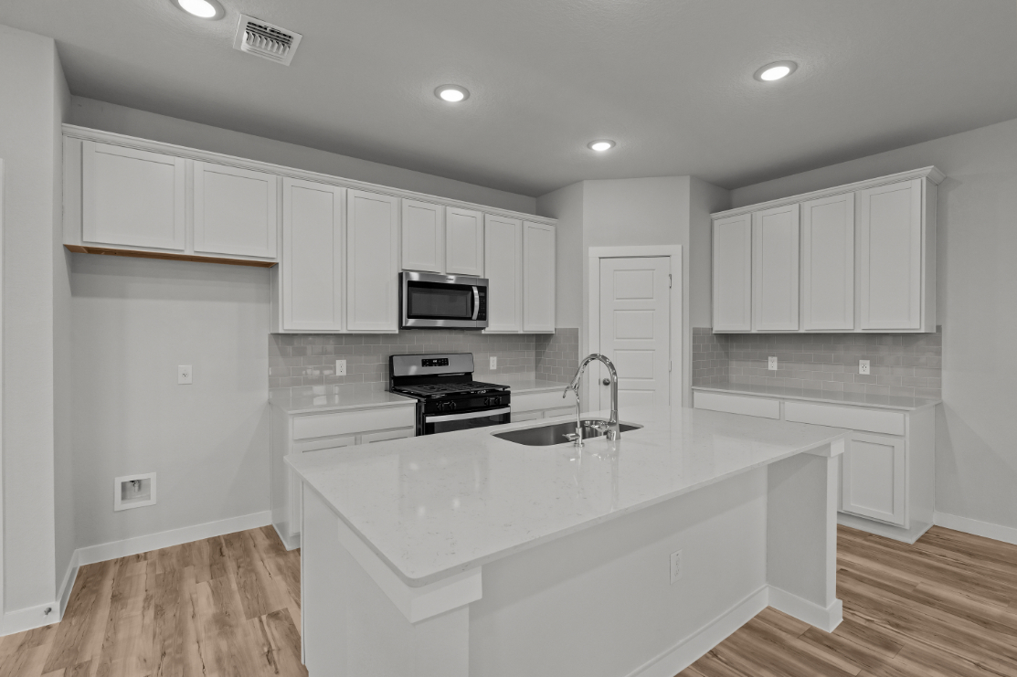 A kitchen with white cabinets.