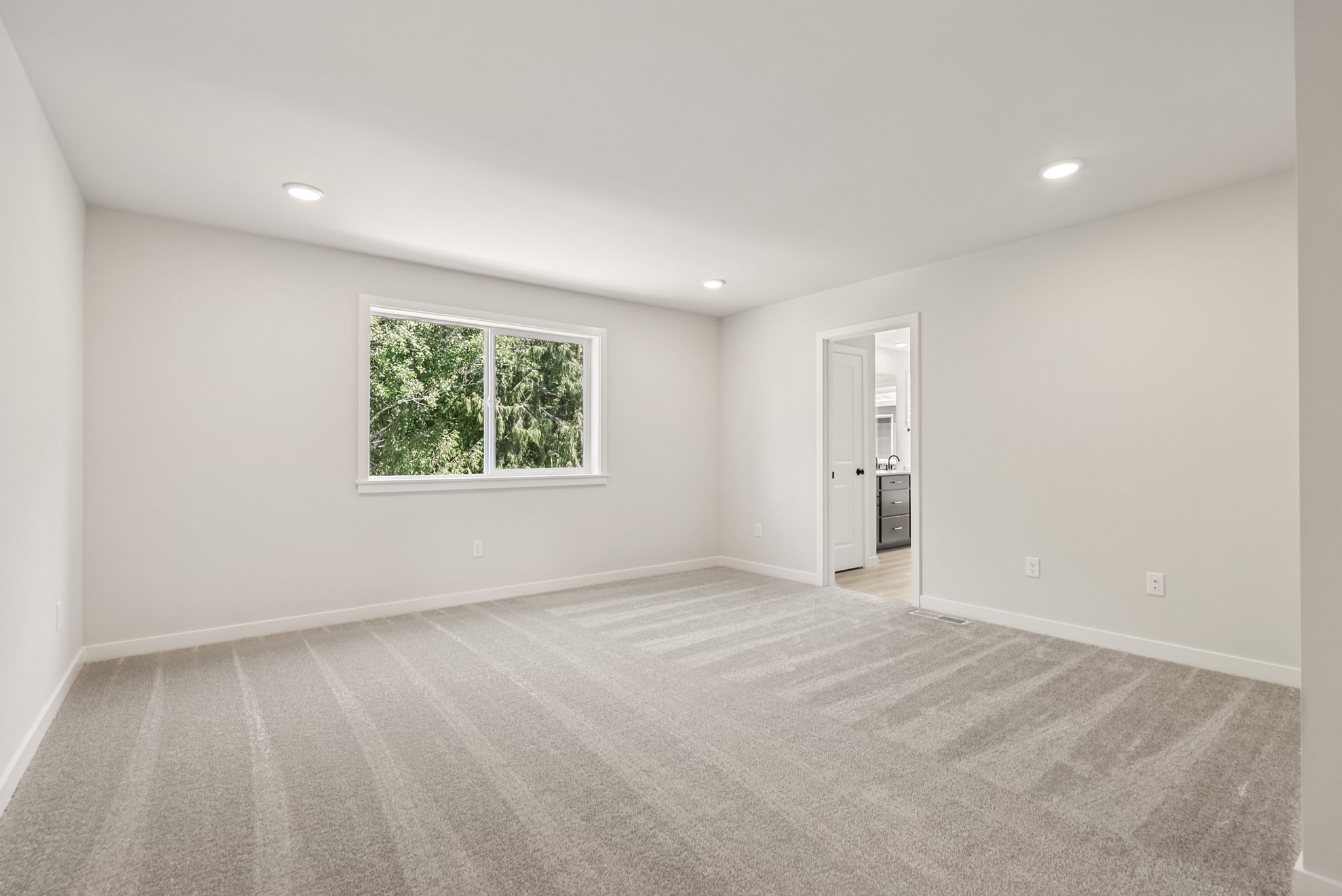 A room with a window and a carpet.