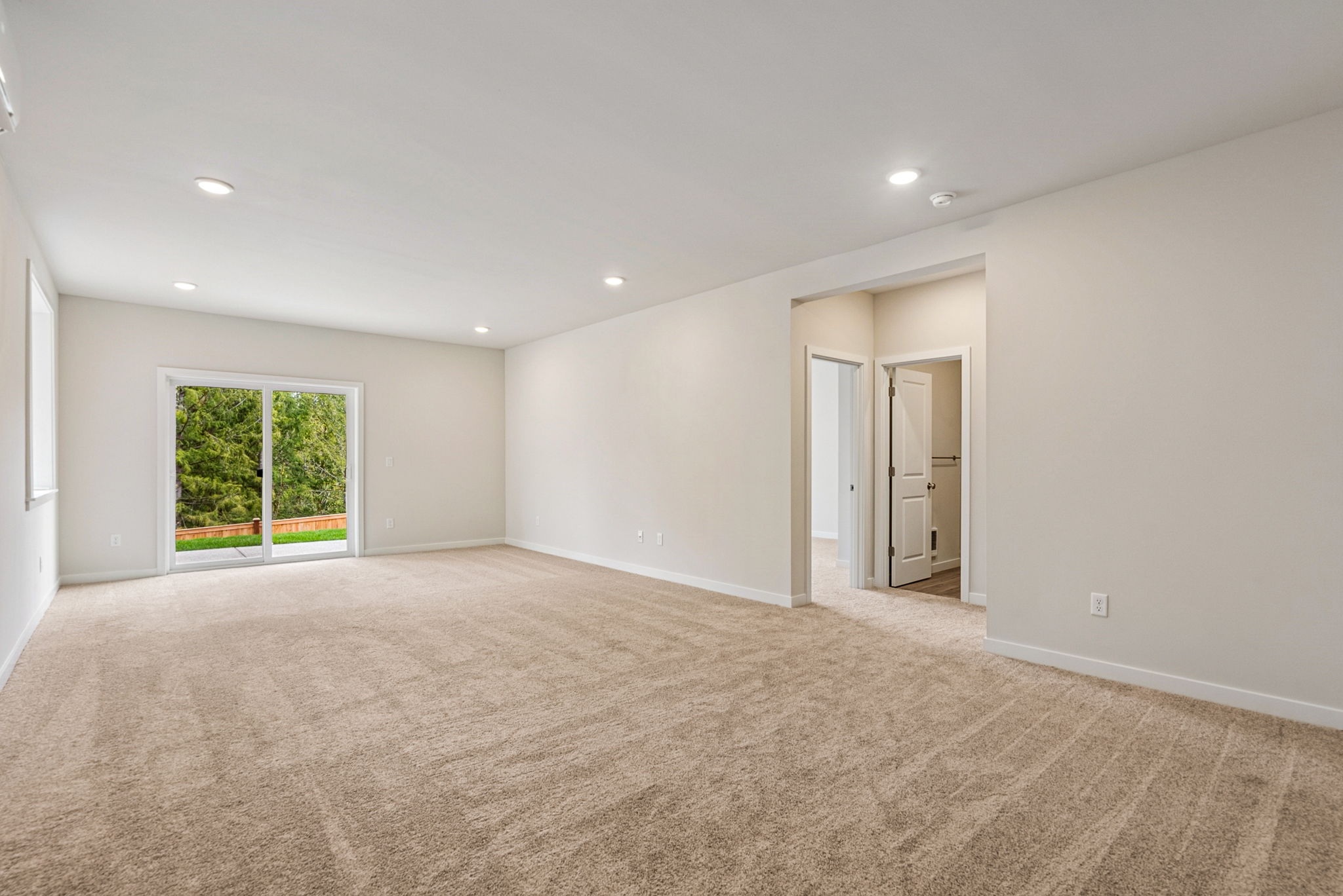 A room with a carpet and a door.