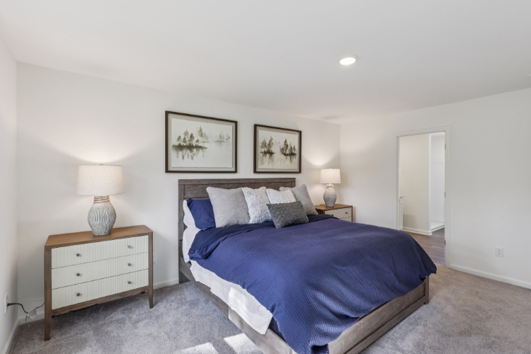 A bedroom with a bed and lamps.