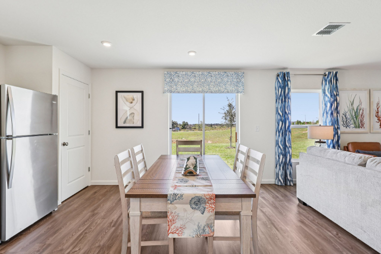 A dining room with a table and chairs.