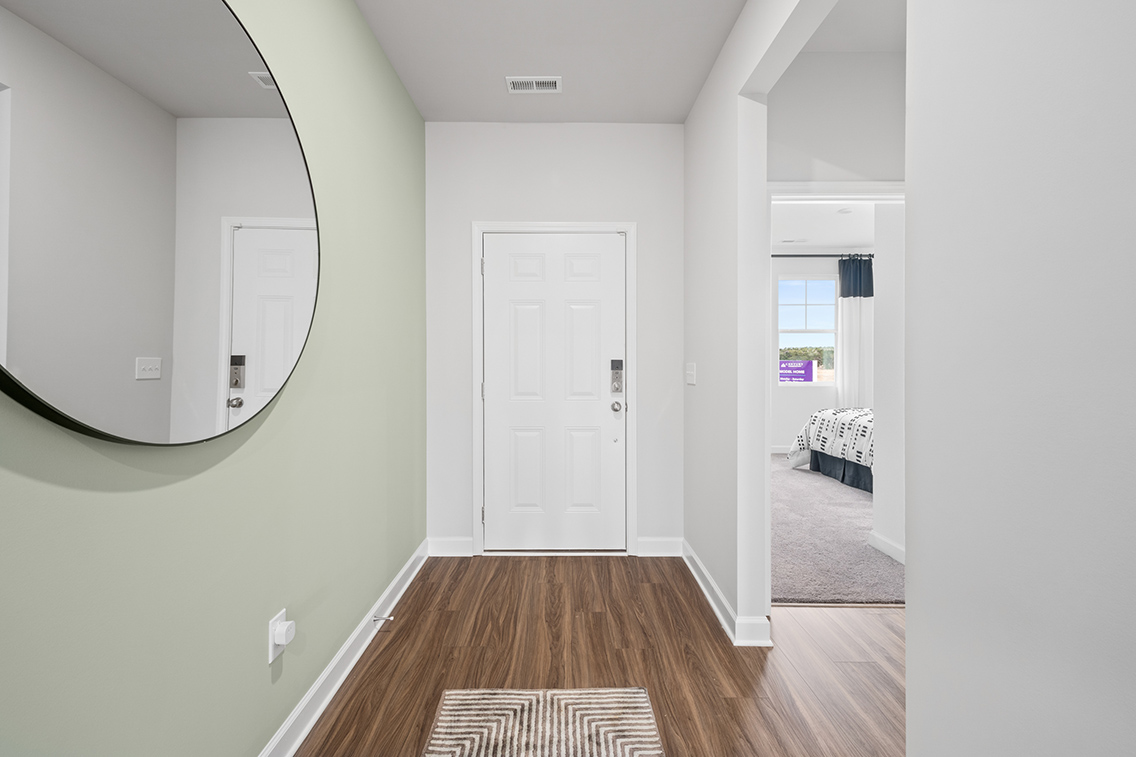 A room with a mirror and a rug.