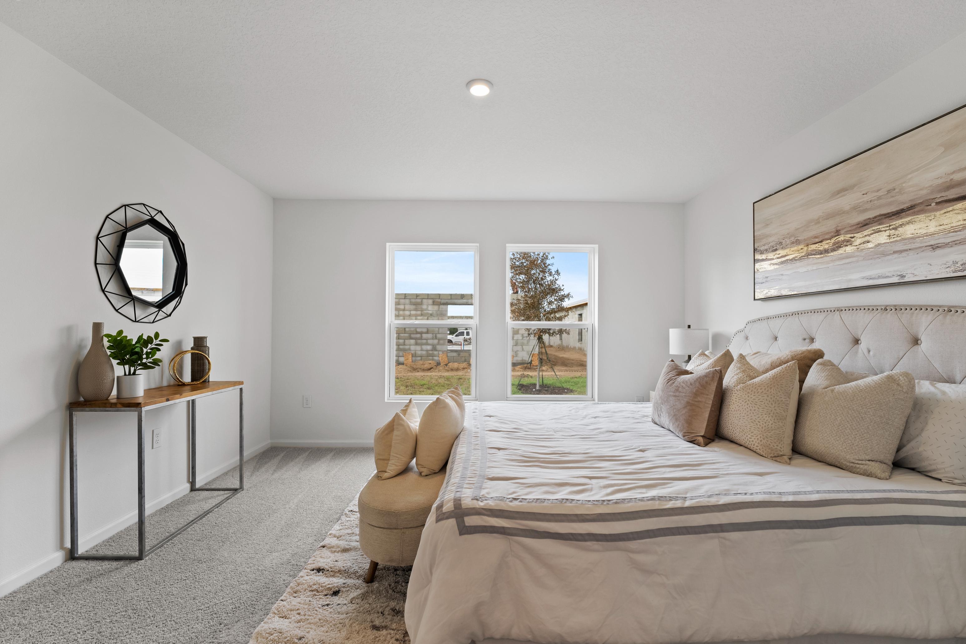 A bedroom with a bed and a chair.