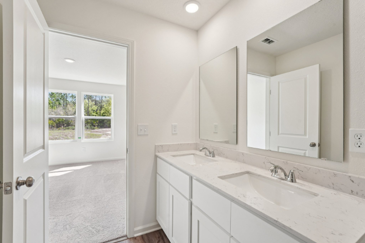 A bathroom with white cabinets.