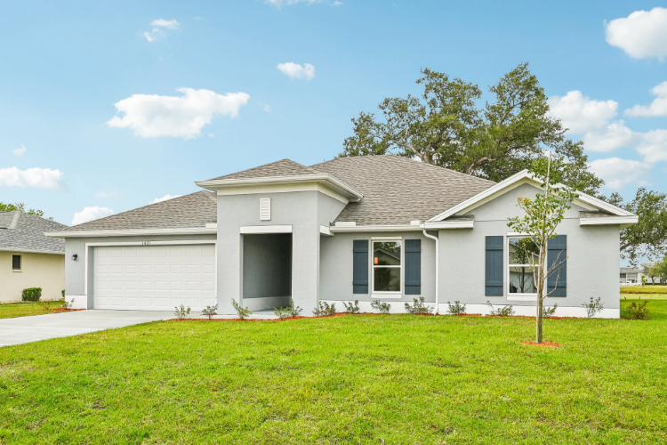 A white house with a lawn in front of it.