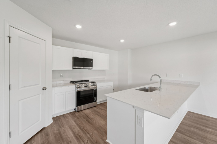 A kitchen with white cabinets.