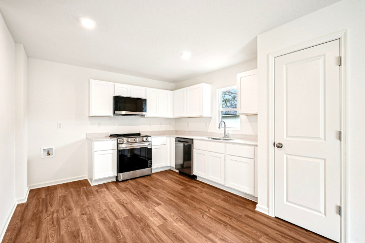 A kitchen with white cabinets.
