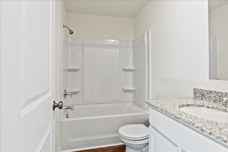 A bathroom with a tub sink and toilet.