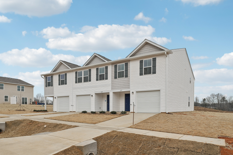 A white house with garages.