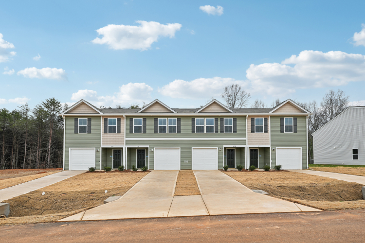 A building with a lot of garages and trees in the background.