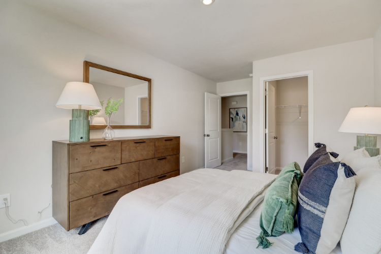 A bedroom with a bed and dresser.