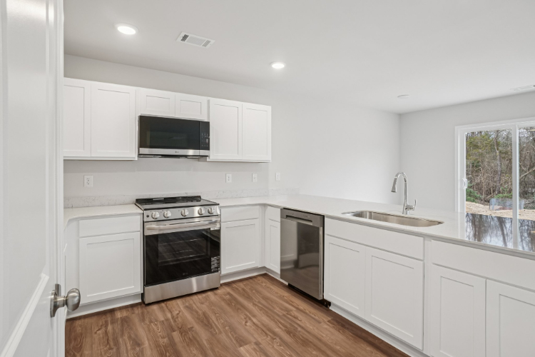 A kitchen with white cabinets.